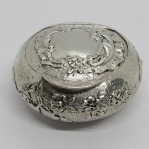 Boîte à pilules en argent massif, fond travaillé, avec fleurs et coquilles, vers 1900.
