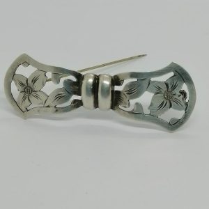 Broche argent, façon noeud ajouré et motif floral, vers 1925-30.