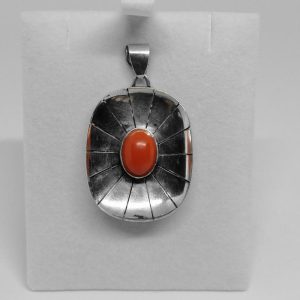 Pendentif argent, ajouré et sertie d&rsquo;un cabochon de corail naturel.